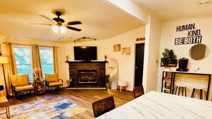 A living room with a fireplace, a dining table, and a motivational wall quote. - TRAVELING WORKERS 3 bdrm/sleeps 6-7 hin Spring Grove/Surry/Prince George (Spring Grove)