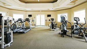 A gym with treadmills, elliptical machines, and a ceiling fan. - Legacy Dunes Retreat Near Disney (Kissimmee)