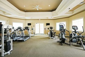 A gym with treadmills, elliptical machines, and a ceiling fan. - Legacy Dunes Retreat Near Disney (Kissimmee)