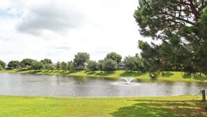 A serene park with a pond, trees, and a fountain. - Legacy Dunes Retreat Near Disney (Kissimmee)