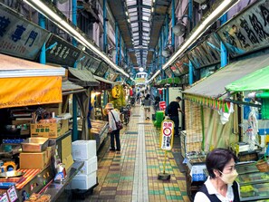 An indoor market with narrow walkways, various stalls, and overhead lighting.