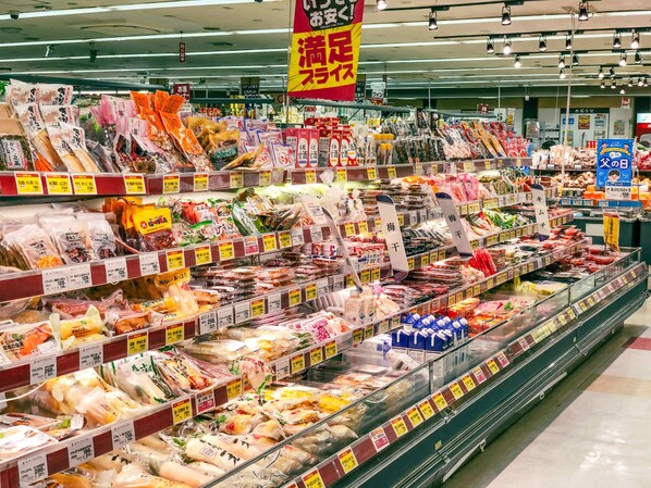 A grocery store aisle with various packaged goods and price tags.