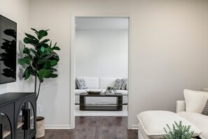 En stue med sofa, sofabord og en plante.