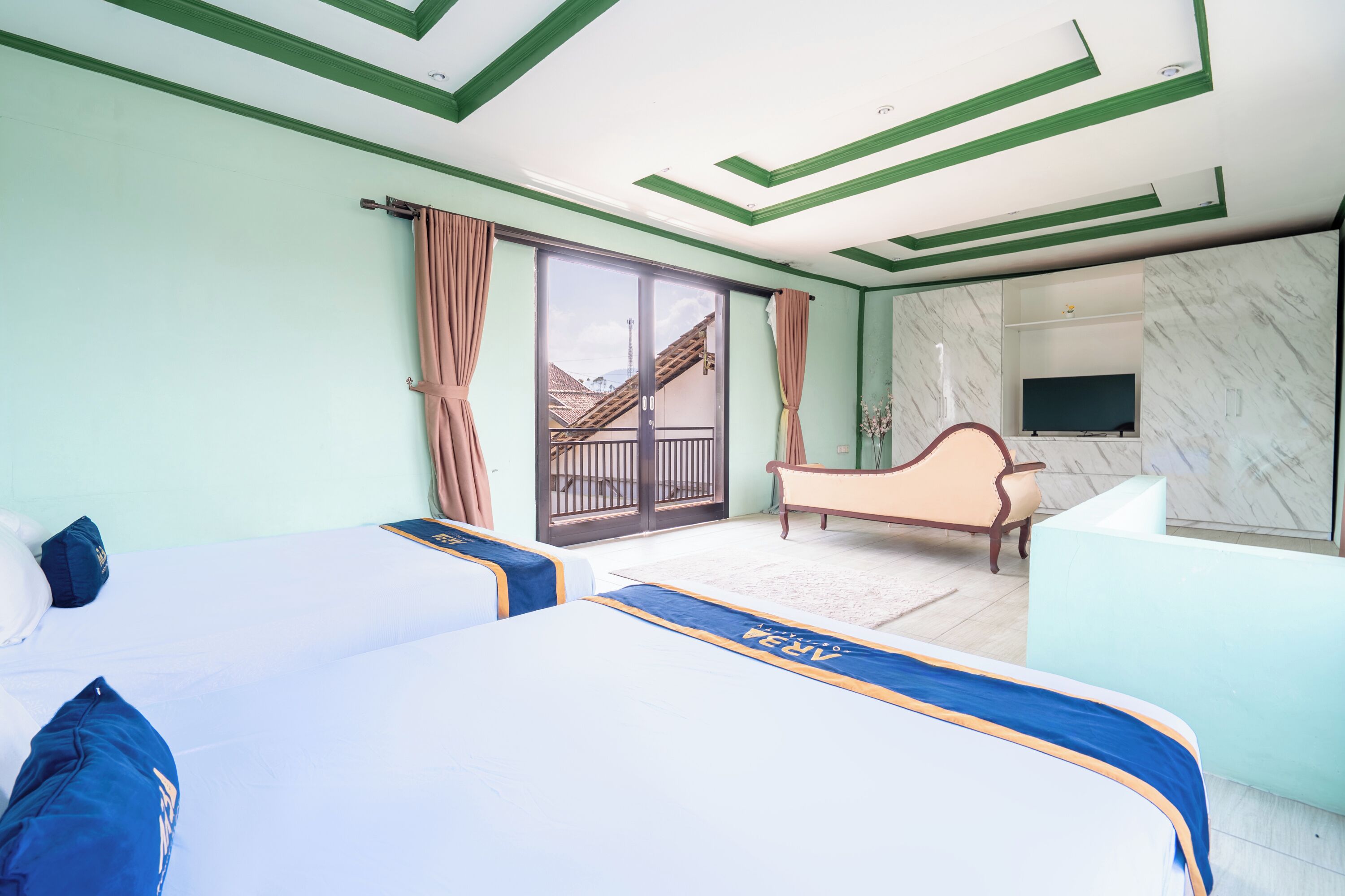 A hotel room with two beds, a sofa, a TV, and a balcony with a view.