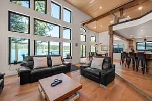 Ein modernes Wohnzimmer mit Sofa, Couchtisch und Essbereich mit Stühlen.