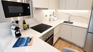 A modern kitchen with a built-in microwave, toaster, and sink.