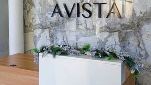 A reception desk with a marble wall background and the word 'AVISTA' in large letters. - Cozy G&C Luxe (Mandeville)