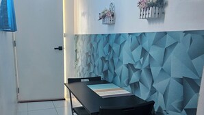 A room with a tiled floor, a black table with chairs, a white door, and a wall with a geometric pattern. - Azul Puerto Del Malecon (Puerto Plata)