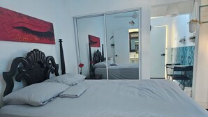 A bedroom with a bed, a mirror, a desk, and a chair. - Azul Puerto Del Malecon (Puerto Plata)
