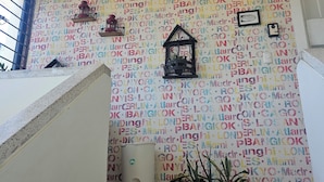 A staircase with a wall decorated with city names in various colors. - Azul Puerto Del Malecon (Puerto Plata)