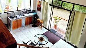 Una cocina amplia con comedor, ventanas grandes y ventilador de techo.