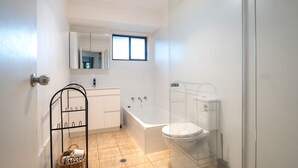A bathroom with a bathtub, toilet, and sink. - The Nook in Mollymook - Walk to the beach! (Mollymook Beach)