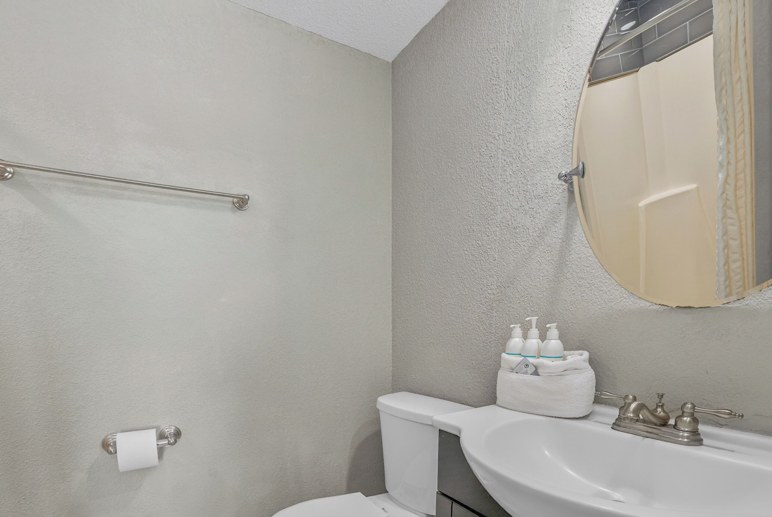 Une salle de bain avec des toilettes, un lavabo et un miroir.