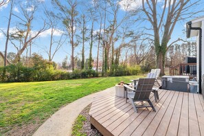 A deck with outdoor seating, a fire pit, and a grill area. - Spacious Raleigh Retreat - 3 BR + Bonus Space - Large Fenced Yard (Raleigh)