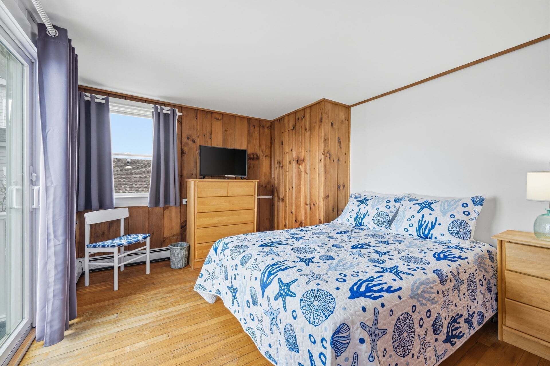 Une chambre à coucher avec un lit, une télévision, un bureau et une chaise.