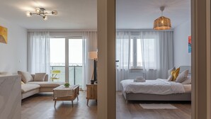 Un salon moderne avec un canapé, une table à manger et une grande fenêtre.