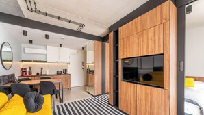 Un salon moderne avec un canapé, une table à manger et une cuisine en arrière-plan.