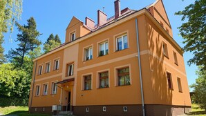 Un immeuble à plusieurs étages, doté d’une façade symétrique, de nombreuses fenêtres et d’une entrée centrale.