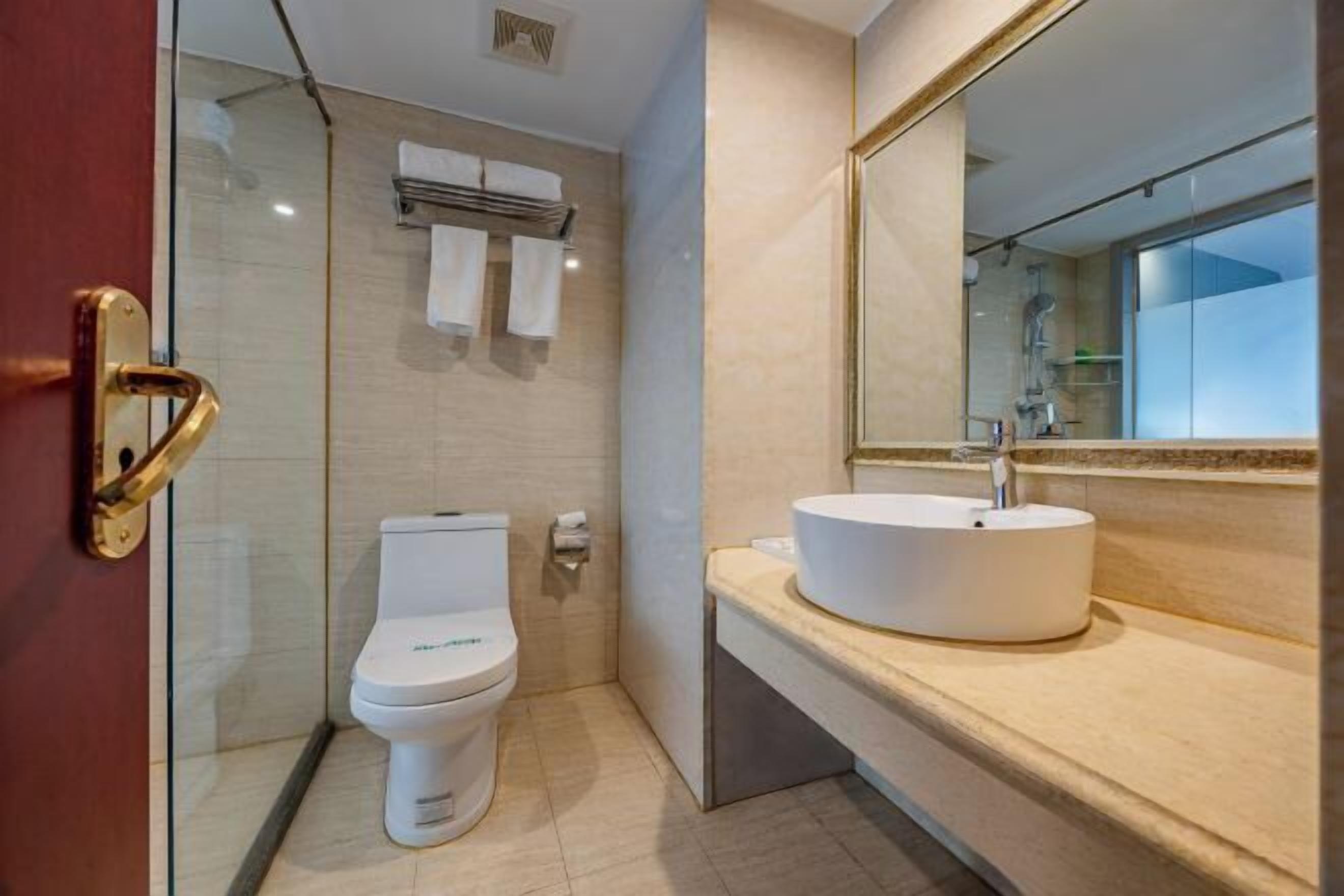 Ein modernes Badezimmer mit Toilette, Waschbecken und einer Duschkabine aus Glas.