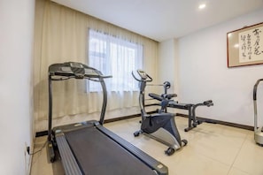 A room with a treadmill, elliptical, and stationary bike.