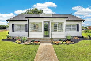 A single-story house with a front door, windows, and a small porch. - The Staytion (College Station)