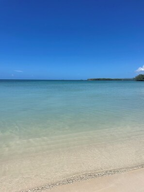 A beach with clear water and a distant landmass. - Your tropical escape in Playa Santa, Guanica. Beach days starts here. (Guánica)