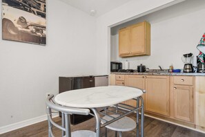 A kitchen with a marble table, wooden cabinets, a microwave, and a coffee maker. - Private 1-Bedroom with Private Entrance Ocala, FL (Ocala)