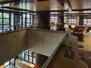 A modern interior with a mezzanine level, large windows, and a mix of seating areas. - Skyline 2-Bed Near Crown with Pool and Sauna (Southbank)
