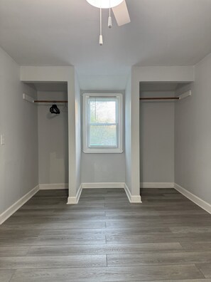 A room with a sloped ceiling, a window with blinds, and a wooden floor. - Perfect 3-bedroom house with AC in beautiful Parma Heights (Parma Heights)