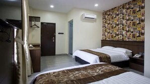 A hotel room with two beds, a wardrobe, a mirror, an air conditioning unit, and a wall decorated with photos. - Islander Lodge by LWE (George Town)