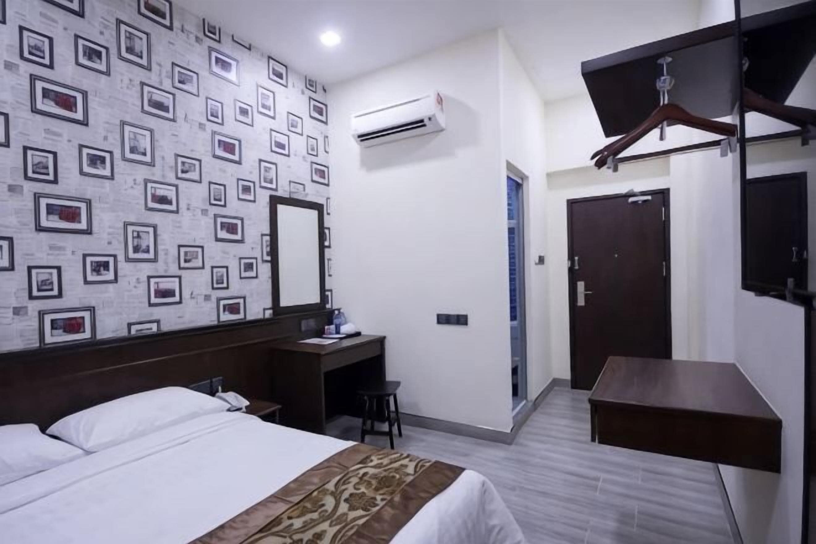 Une chambre d’hôtel équipée d’un lit, d’un bureau, d’une armoire et d’un appareil de climatisation.