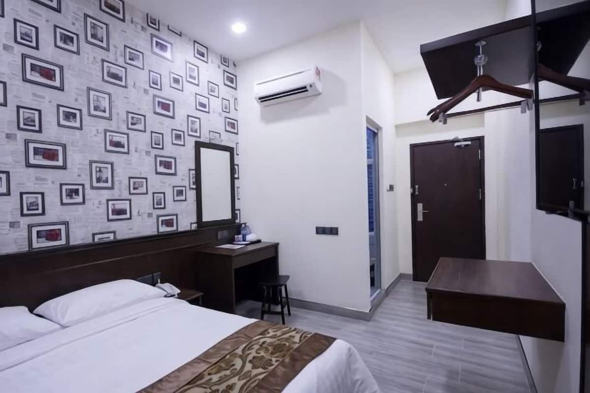Une chambre d’hôtel équipée d’un lit, d’un bureau, d’une armoire et d’un appareil de climatisation.