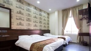A hotel room with two beds, a desk, a mirror, and a window with curtains. - Islander Lodge by LWE (George Town)