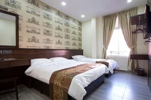 A hotel room with two beds, a desk, a mirror, and a window with curtains. - Islander Lodge by LWE (George Town)