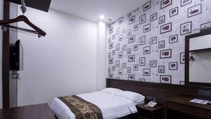 A hotel room with a bed, bedside table, and a mirror. - Islander Lodge by LWE (George Town)