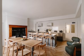 Eine moderne Küche mit einer zentralen Kochinsel, einem Holzespeisetisch und Stühlen.