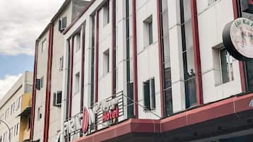Un edificio alberghiero a più piani con un cartello ben visibile che indica la presenza di un hotel.