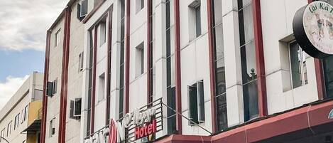 Een hotelgebouw met meerdere verdiepingen en een opvallend bord dat het als hotel identificeert.