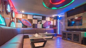 A modern living room with a leather sofa, glass-top coffee tables, and a flat-screen TV. - Paragon Nagoya Hotel Batam (Batam)