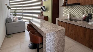 Eine moderne Küche mit Granitarbeitsplatte, Holzschränken und einem eingebauten Ofen.