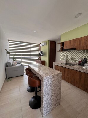 Eine moderne Küche mit Granitarbeitsplatte, Holzschränken und einem eingebauten Ofen.