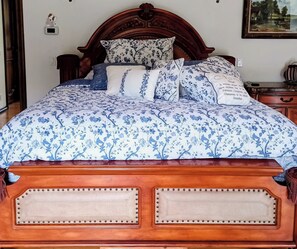 A bed with a floral-patterned bedspread, a wooden headboard, and several pillows. - Stunning Malibu 7 Bedroom Mansion/Castle with Swimming Pool (Malibu)