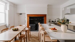 Een moderne keuken met een centraal eiland, houten stoelen en een eettafel.