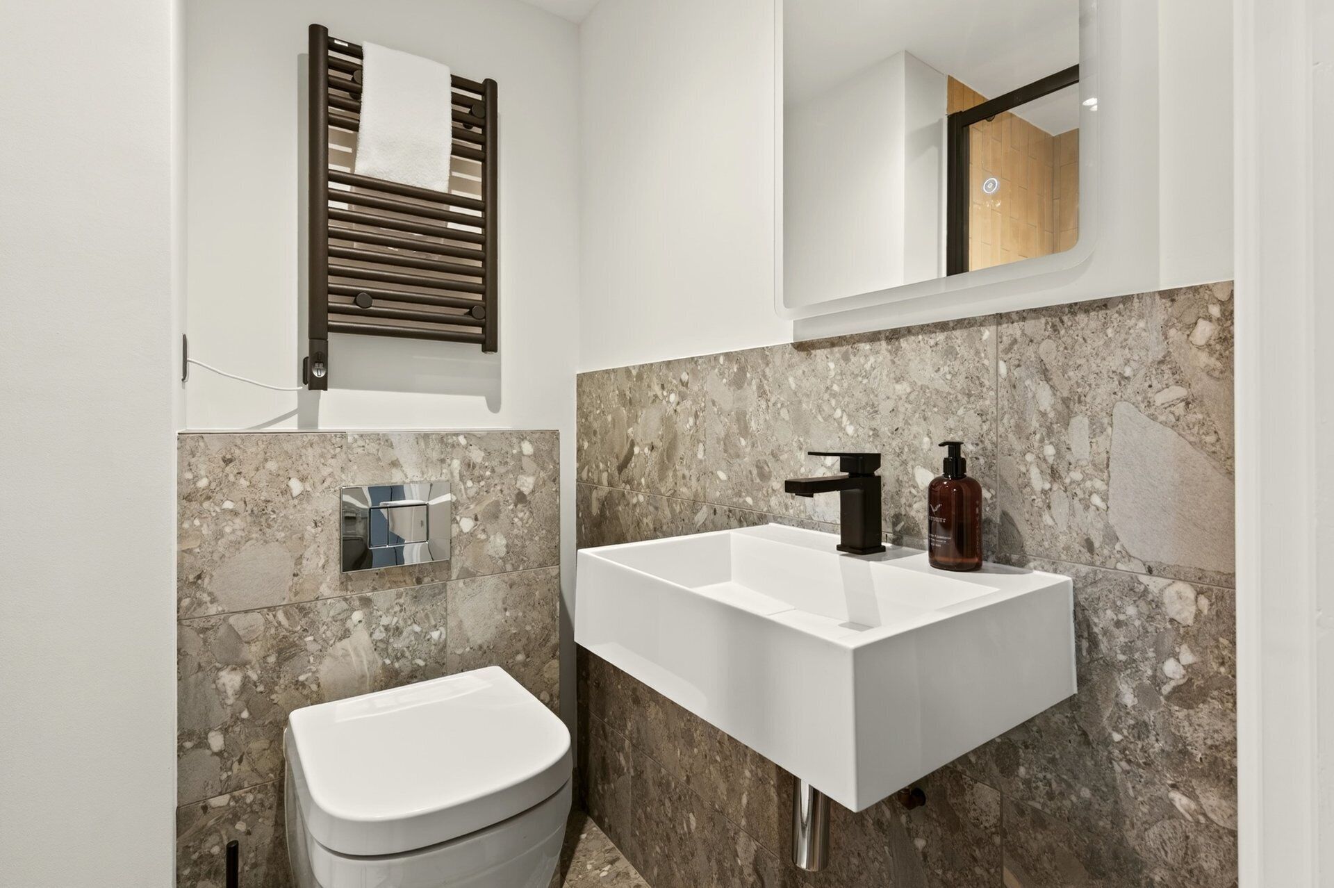 A bathroom with a white sink, a toilet, and a mirror.