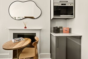 A modern kitchen with a built-in oven, a coffee machine, and a microwave. - GuestReady - Modern Double Room near King's Cross (London)