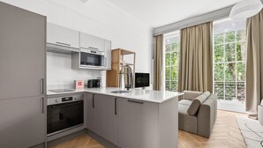Une cuisine moderne avec des meubles de couleur grise, un four à micro-ondes encastré et une machine à café.