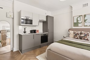 A modern bedroom with a bed, a nightstand, and a bedside table. - GuestReady - Quiet Double En-Suite in WC1 (London)