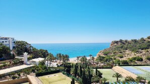 A coastal resort with a tennis court, beach, and a building with arched windows. - Beautiful apartment overlooking the Mediterranean. (Villajoyosa/Vila Joiosa, La)