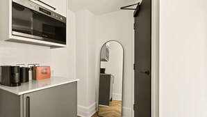 Eine moderne Küche mit Einbauofen, Kühlschrank und Kaffeemaschine.