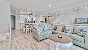 Ein modernes Wohnzimmer mit Sofa, Couchtisch und Essbereich.